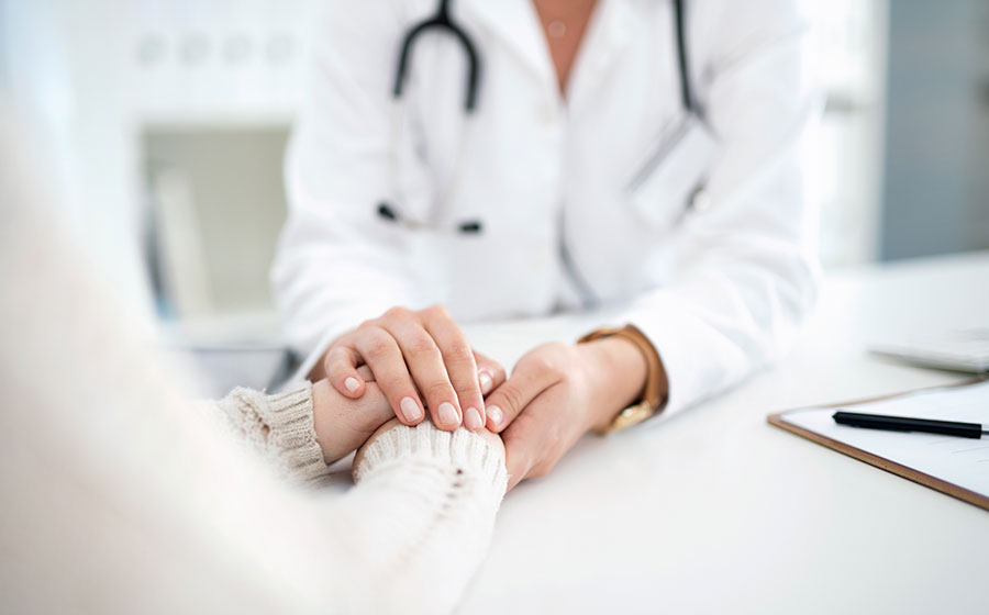 Médica segurando a mão da paciente